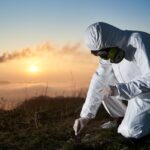 Scientist taking sample of ground at thermal power station.